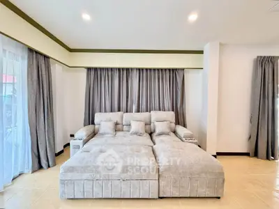 Spacious living room with plush gray sectional sofa and elegant curtains