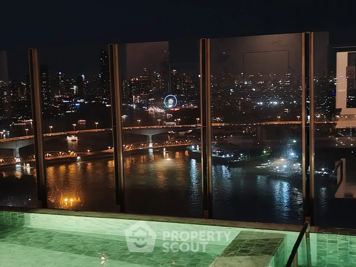 Stunning rooftop pool with breathtaking city skyline view at night.
