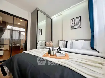 Modern bedroom with stylish decor and large mirrored wardrobe