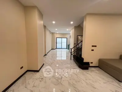 Spacious modern living room with marble flooring and elegant staircase