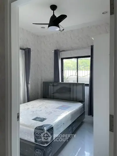 Modern bedroom with stylish ceiling fan and natural light