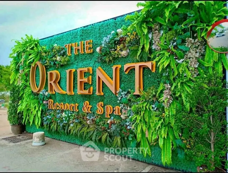 Luxurious entrance of The Orient Resort & Spa with lush greenery and elegant signage.