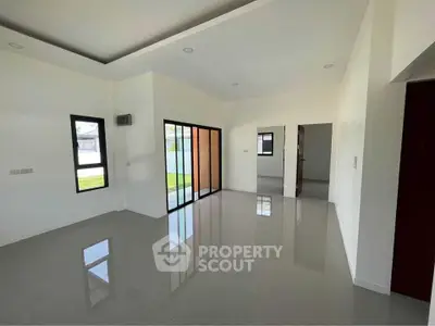 Spacious modern living room with large windows and sleek flooring