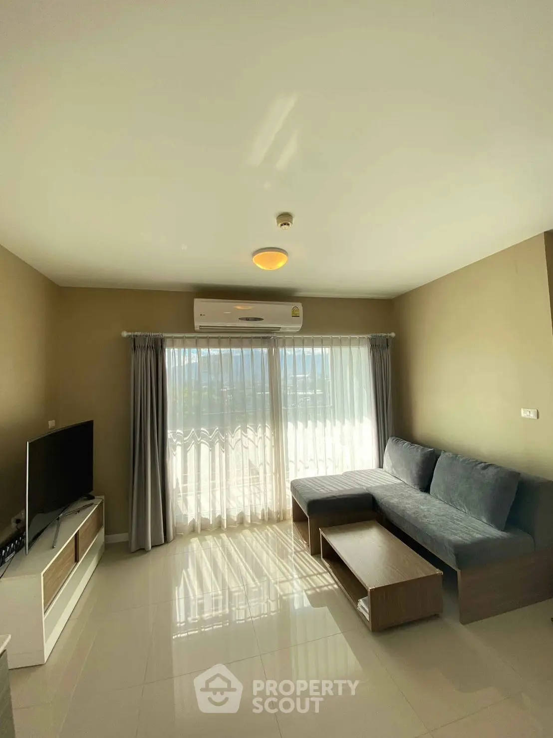 Bright living room with modern sofa and large window offering natural light.