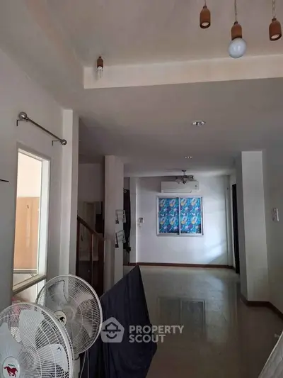 Spacious interior hallway with ceiling lights and fans, ideal for modern living.