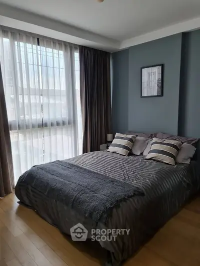 Cozy bedroom with modern decor and large window for natural light