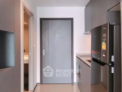 Modern kitchen with sleek appliances and minimalist design in a compact apartment.