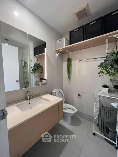 Modern bathroom with sleek vanity, organized storage, and stylish decor plants.