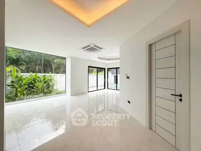 Spacious modern living room with large windows and garden view, perfect for natural light lovers.