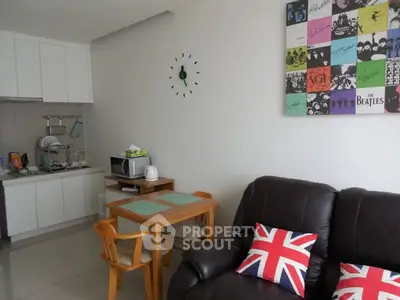Cozy living room with Beatles artwork and compact kitchen area