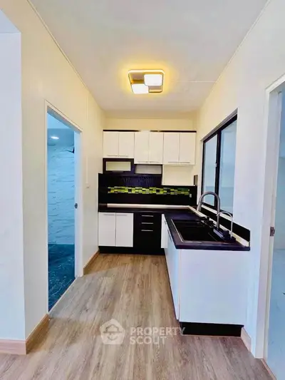 Modern kitchen with sleek cabinetry and stylish backsplash in a contemporary apartment.