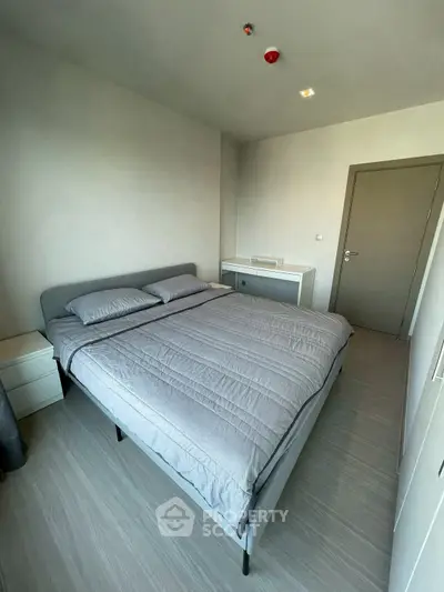 Modern bedroom with minimalist design and cozy bedding in a stylish apartment.