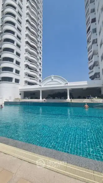 Luxurious high-rise building with stunning pool and clear blue sky.