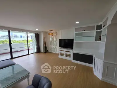 Spacious living room with modern decor and large balcony access, perfect for relaxation and entertainment.