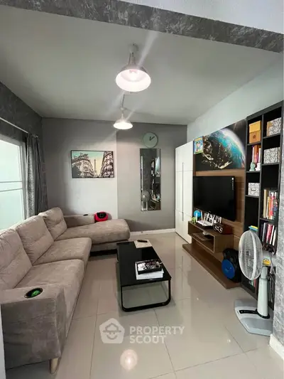 Modern living room with cozy sectional sofa and sleek entertainment center.