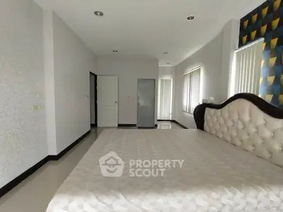 Spacious bedroom with elegant headboard and modern decor