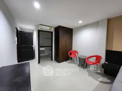 Modern apartment interior with sleek design and vibrant red chairs