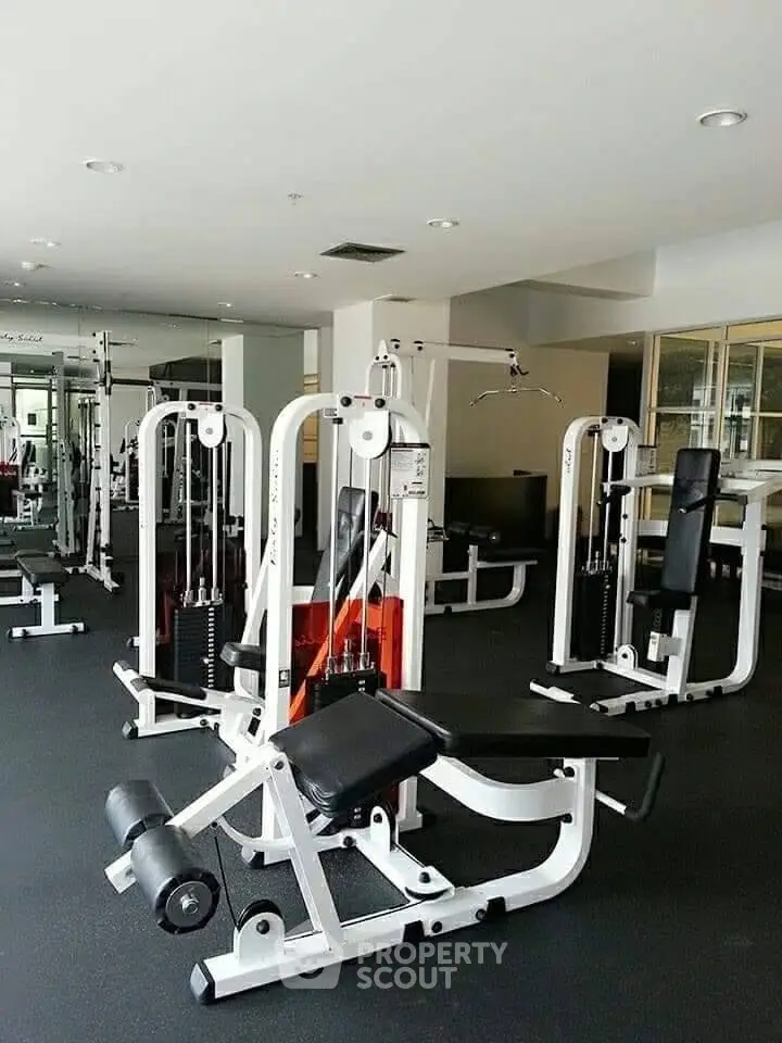 Spacious modern gym with state-of-the-art fitness equipment in a luxury residential building.