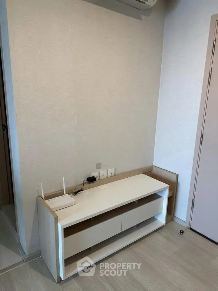 Modern minimalist interior with sleek white cabinet and neutral walls, perfect for stylish living spaces.