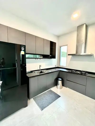 Modern kitchen with sleek black appliances and gas stove in a stylish home.