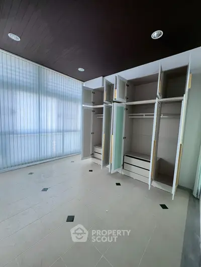 Spacious room with built-in wardrobes and large windows, perfect for modern living.
