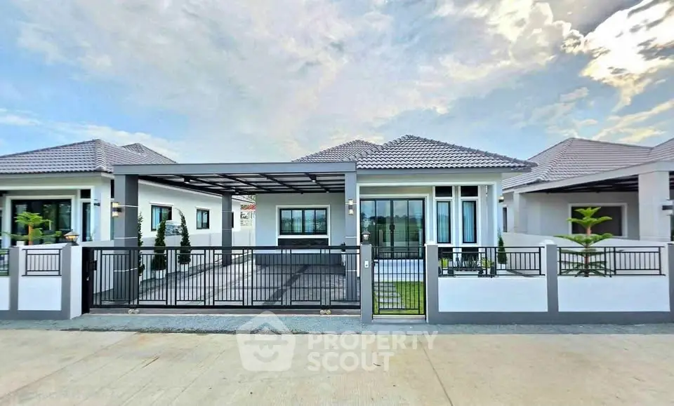 Modern single-story house with gated driveway and contemporary design.
