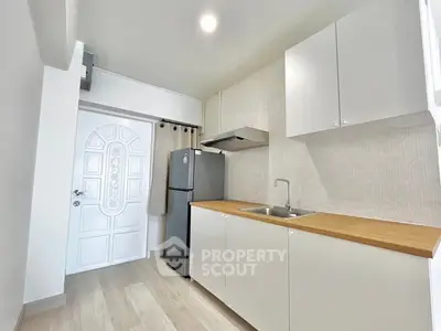 Modern kitchen with sleek cabinets and stainless steel fridge in bright apartment