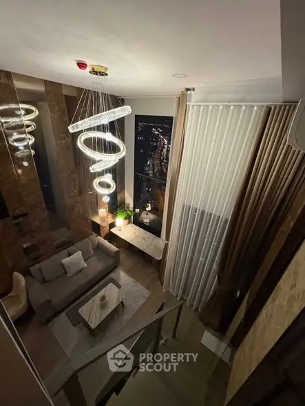 Luxurious high-ceiling living room with modern chandelier and city view