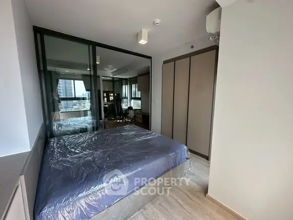 Modern bedroom with glass partition and city view in a stylish apartment