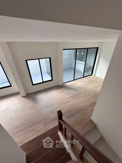 Spacious modern living room with large windows and wooden flooring
