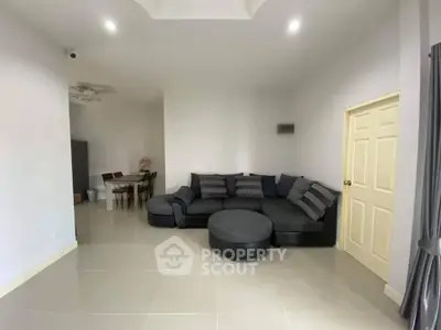 Spacious living room with modern sectional sofa and dining area in open layout