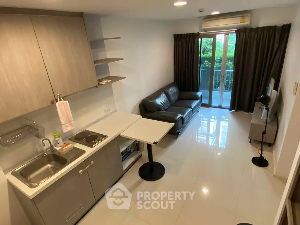 Modern compact living room with kitchenette and balcony view