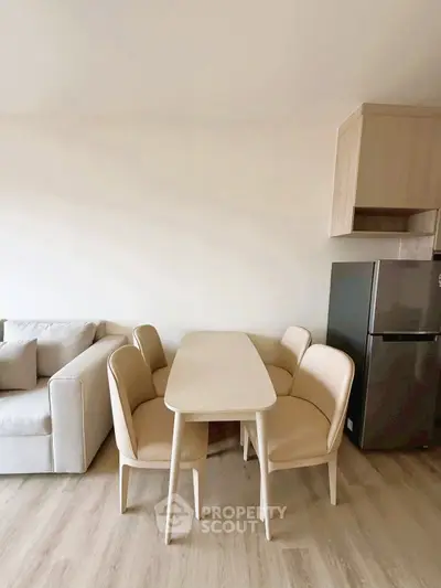 Modern dining area with sleek table, chairs, and adjacent sofa in a stylish apartment.