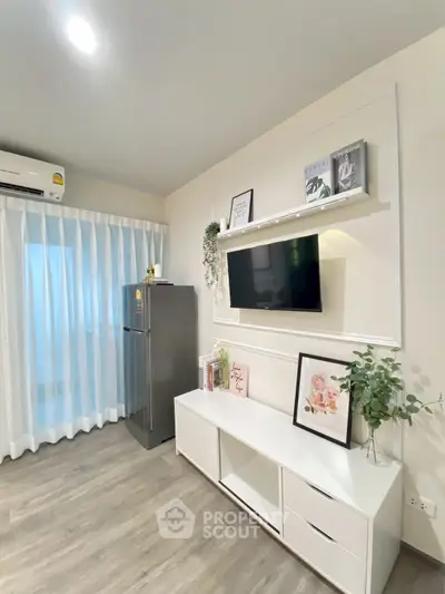 Modern living room with sleek decor and wall-mounted TV, featuring stylish shelving and natural light.