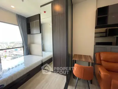 Modern bedroom with city view, featuring stylish furniture and ample natural light.