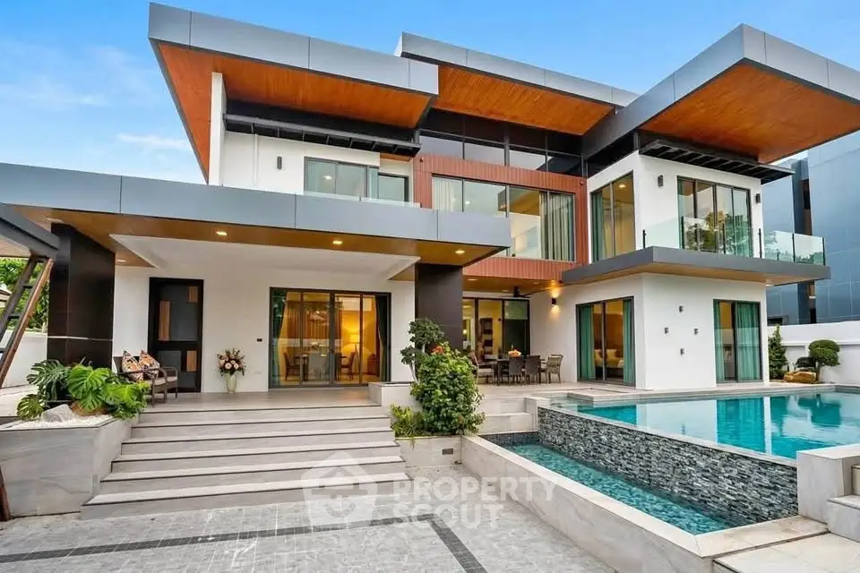Luxurious modern villa with pool and spacious terrace, featuring sleek architectural design and large windows.