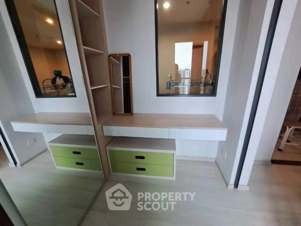 Modern bedroom with built-in storage and stylish mirror in a contemporary apartment.