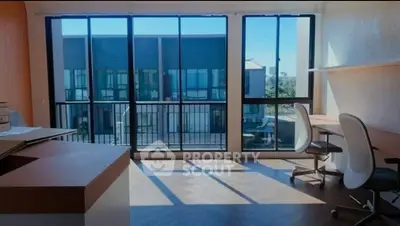 Spacious study room with large windows and modern furniture, offering a bright and inspiring workspace.