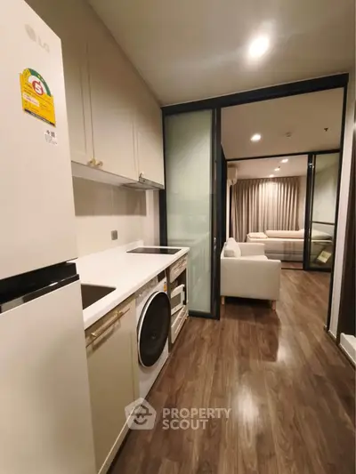 Modern kitchen with sleek appliances and open view to cozy living room