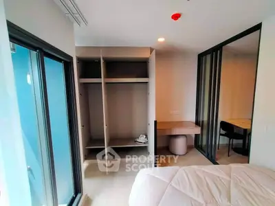 Modern bedroom with open closet and study area in a stylish apartment