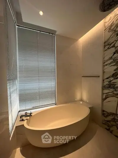 Luxurious bathroom with elegant marble accents and modern bathtub design.
