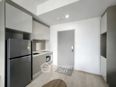Modern kitchen with sleek cabinetry and stainless steel appliances in a stylish apartment.