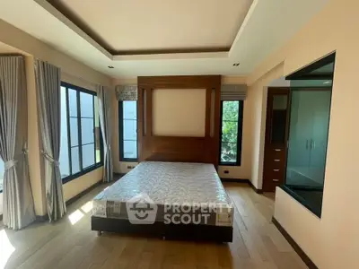 Spacious bedroom with large windows and elegant wooden accents