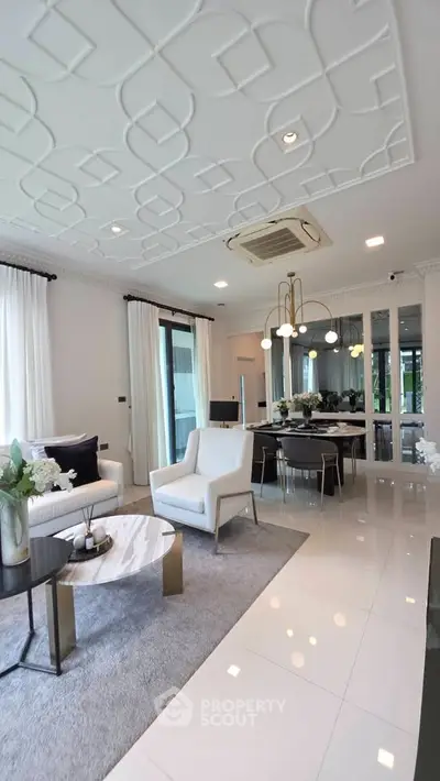 Luxurious modern living room with elegant decor and stylish furniture, featuring a chic ceiling design and large windows.