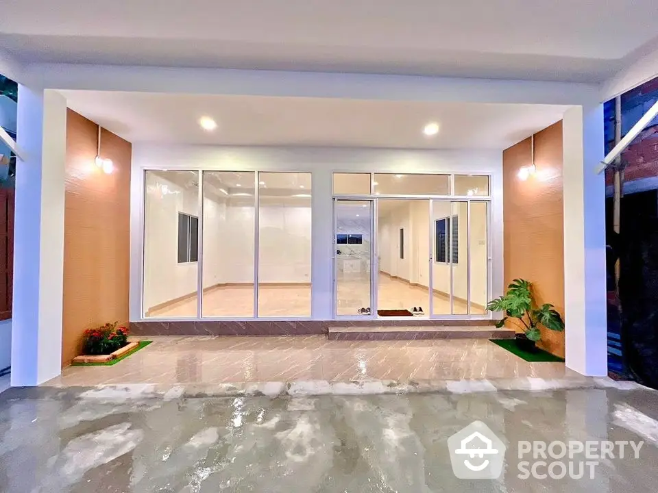 Modern home entrance with large glass doors and sleek lighting