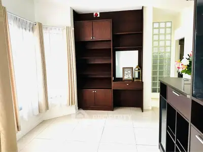 Spacious living room with elegant built-in wooden shelves and large windows
