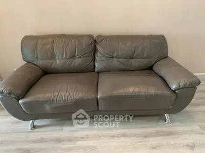 Stylish brown leather sofa on modern wooden flooring in a cozy living room setting.