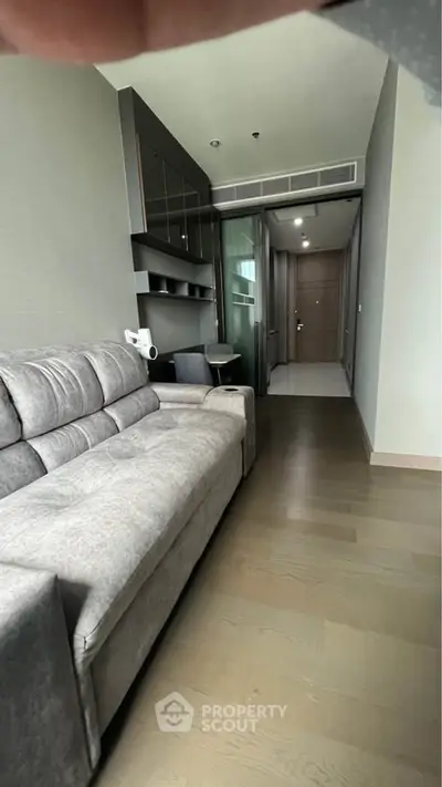 Modern living room with sleek gray sofa and stylish decor in a contemporary apartment.