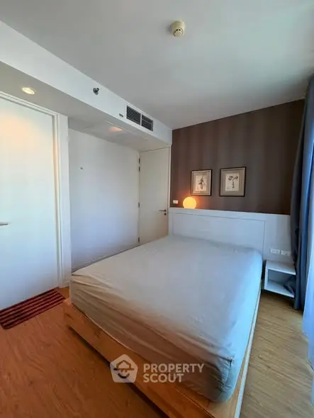 Modern bedroom with wooden flooring and stylish decor in a cozy apartment.