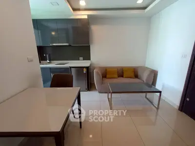 Modern living room with sleek kitchen, cozy sofa, and elegant dining area in open layout apartment.